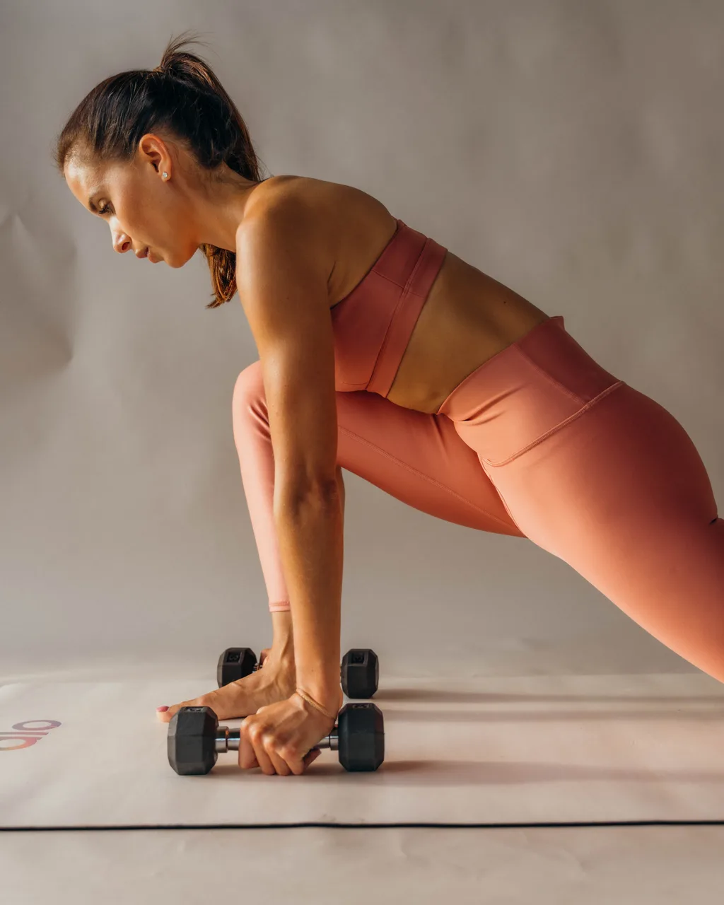Kelsey Rose lunging over dumbbells
