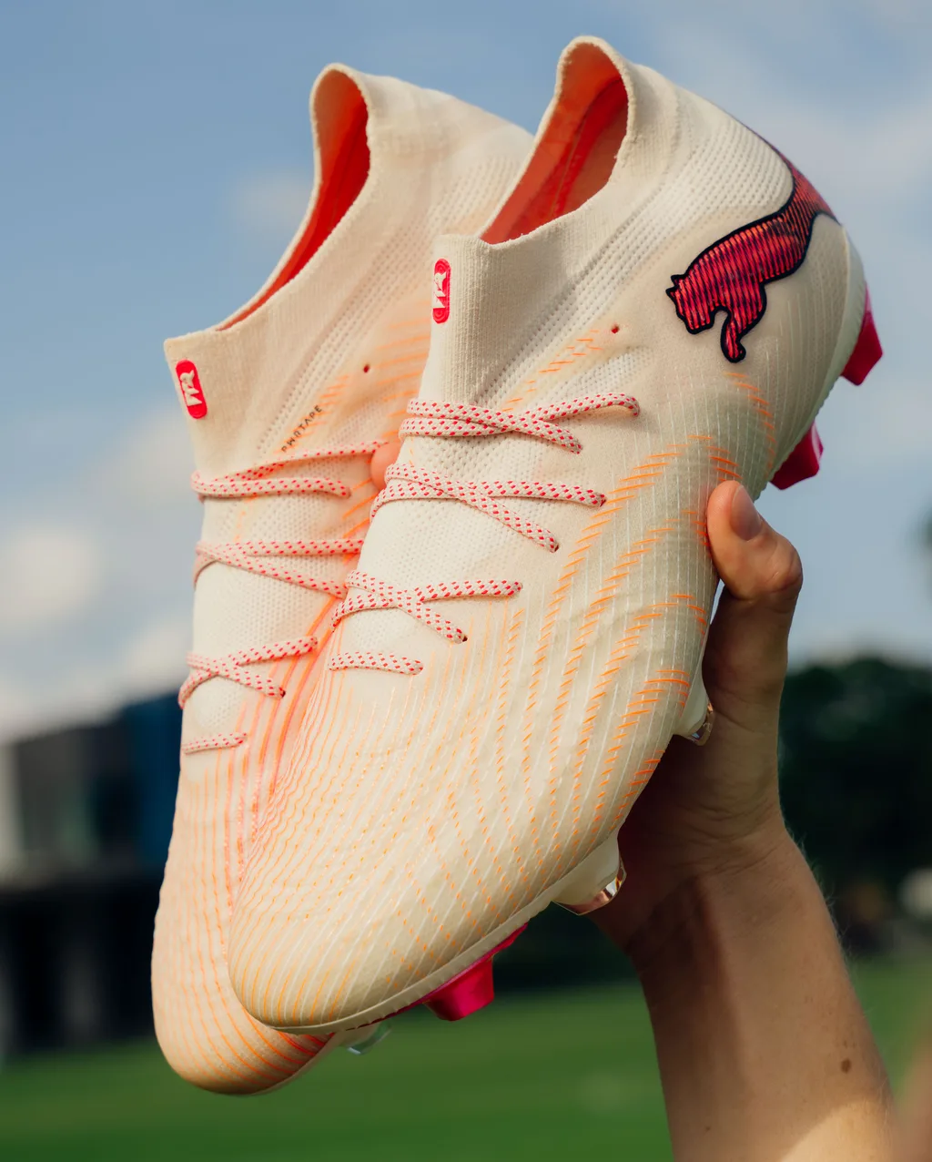 PUMA FUTURE 9 boots held up against the sky
