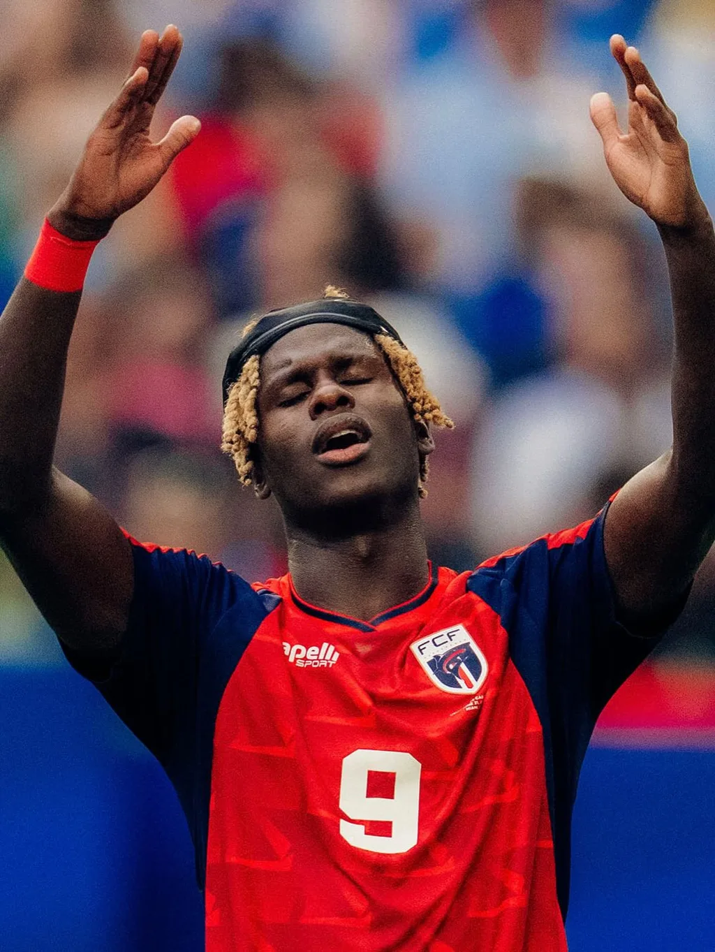 Cabo Verde number 9 raising his arms toward the crowd