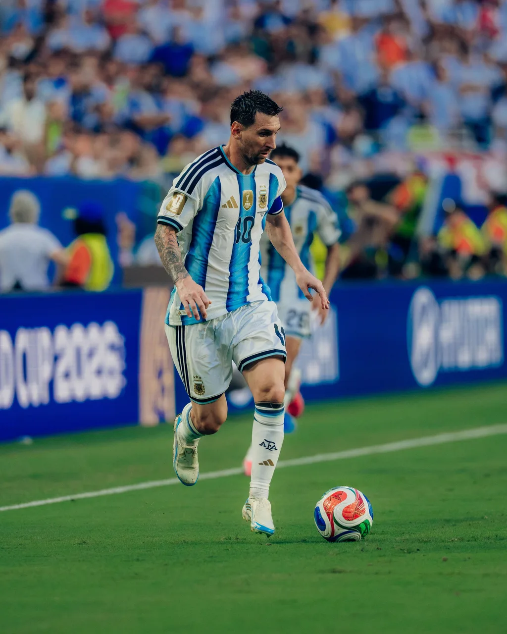 Lionel Messi driving forward with the ball along the touchline