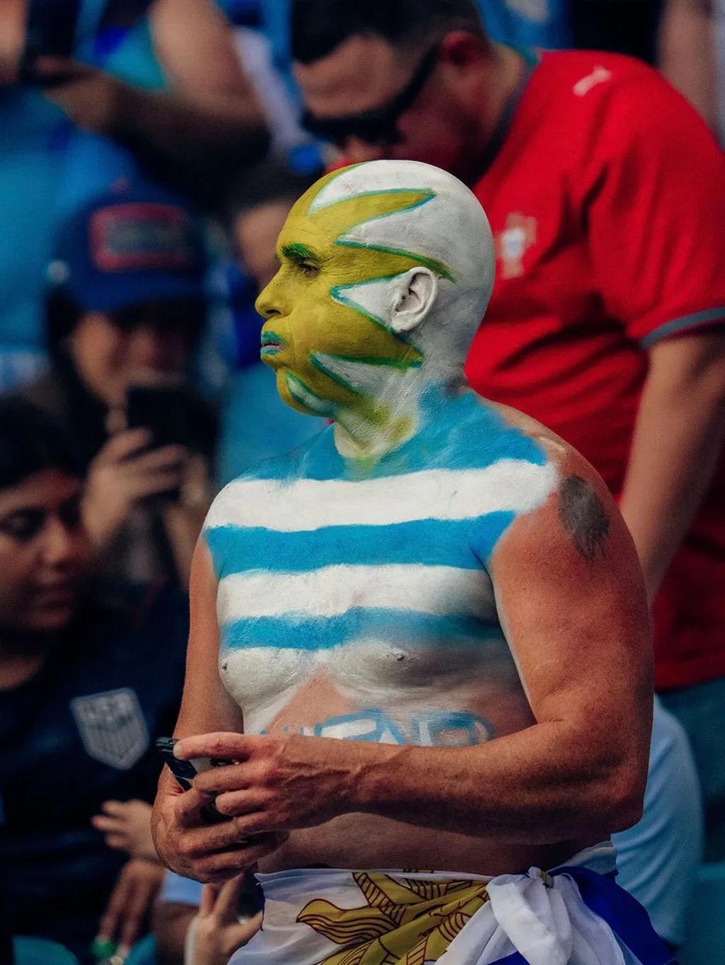 A Uruguay fan with his face and chest painted in the national colours